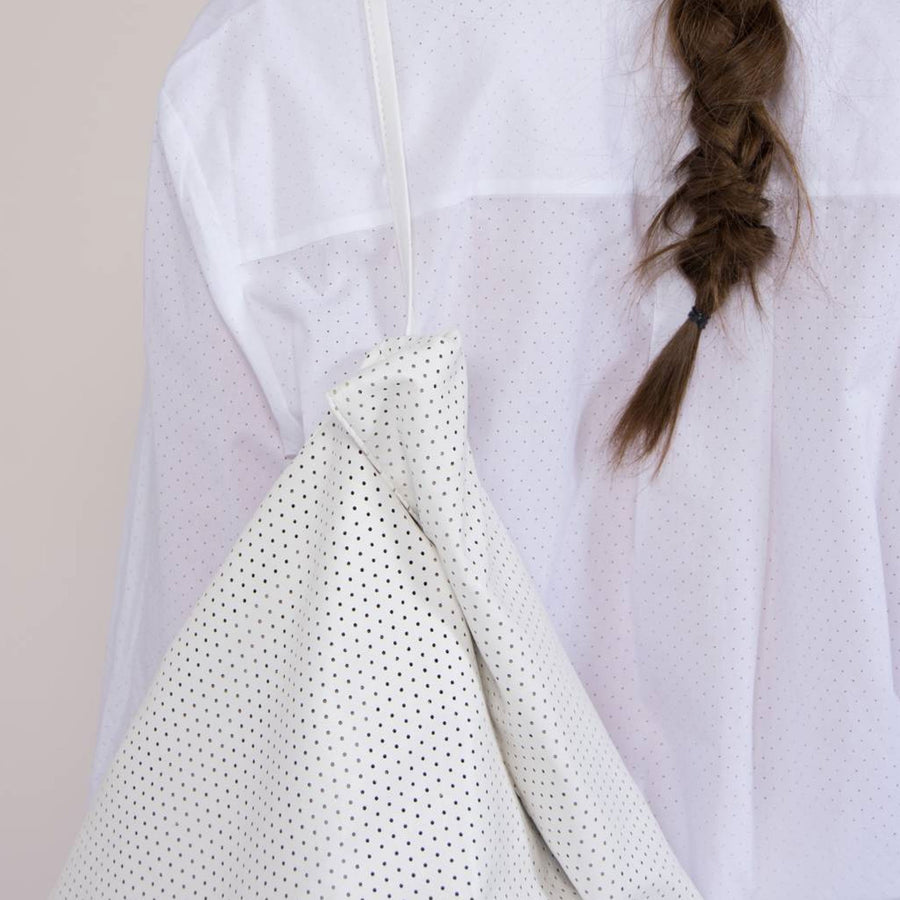 Deze witte geperforeerde Tinne+Mia Feel Good Backpack is gemaakt van soepel vegan leather, gevouwen en verpakt in een mooie minimalistische etui. Aan de zijkant zit een opbergzakje met rits.