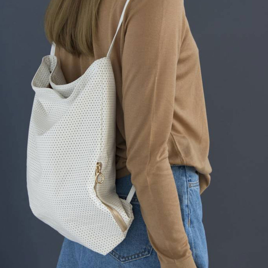 Deze witte geperforeerde Tinne+Mia Feel Good Backpack is gemaakt van soepel vegan leather, gevouwen en verpakt in een mooie minimalistische etui. Aan de zijkant zit een opbergzakje met rits.